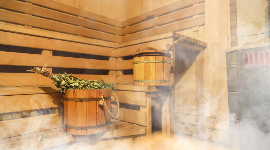 sauna full of steam smoke and bucket with herbal plant