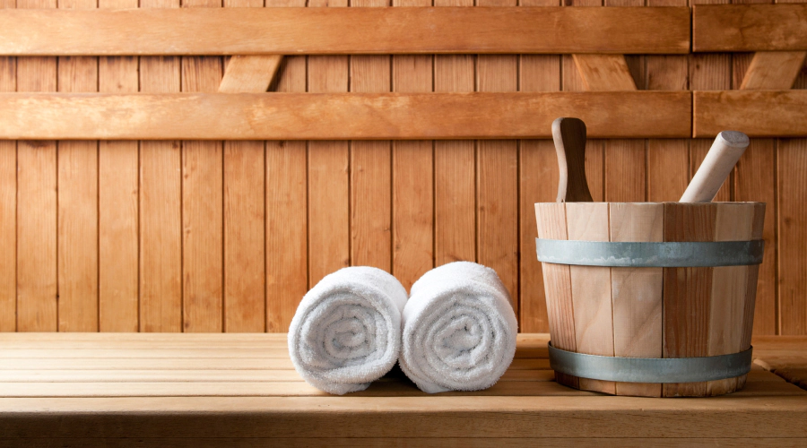 wooden bucket and towel on top of wooden sauna